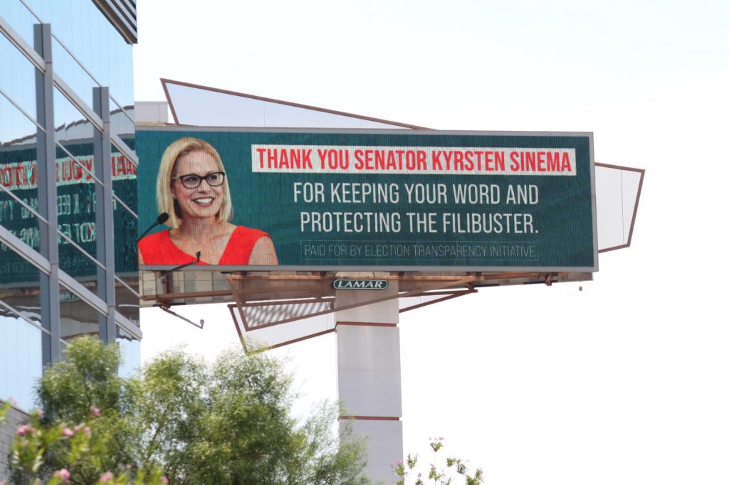 highway billboard sign thanks Senator Kyrsten Sinema for "protecting the filibuster.