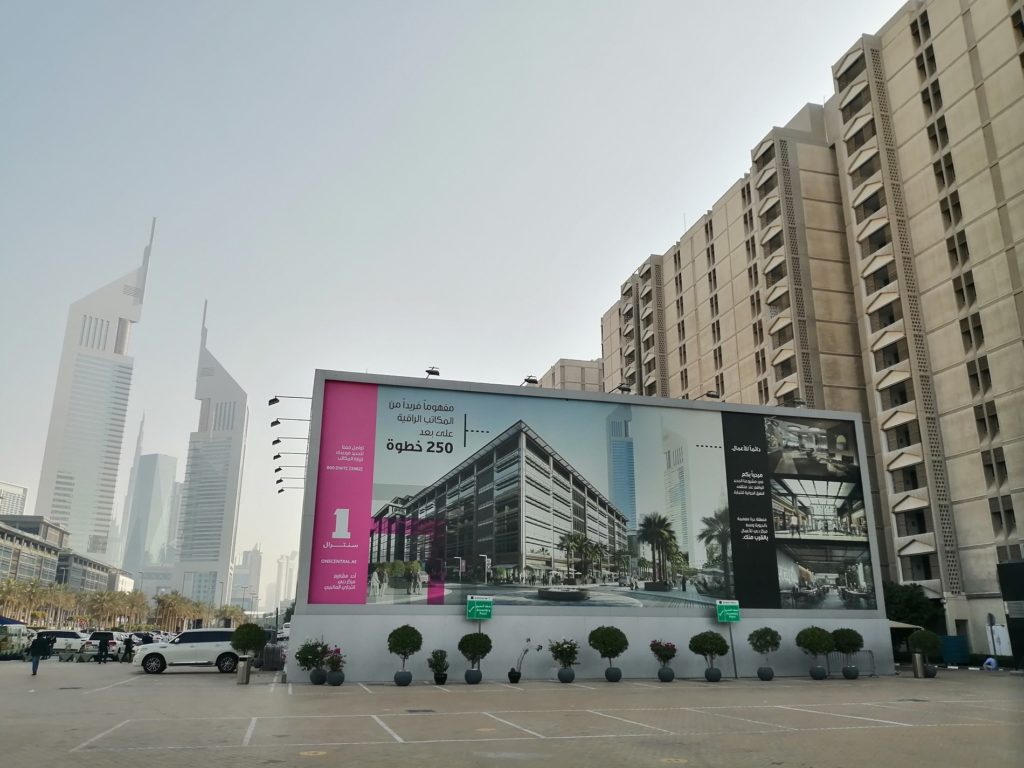 Large outdoor advertising (out of home) billboard (hoarding) panel with marketing campaign on a street